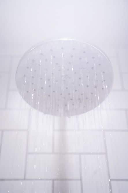 A close up photo showing a showerhead with steaming water coming out.