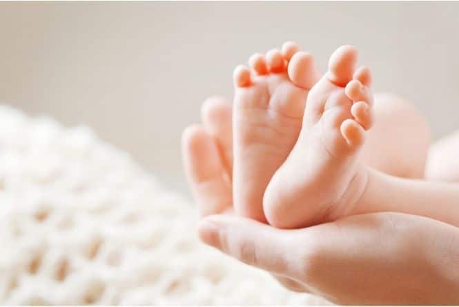 Make a child feel special on their birthday by reminiscing. This is a picture of two baby feet in an adult hand.