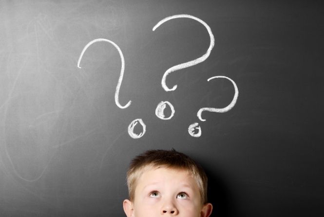 Do you wonder when and how to teach manners to kids? This is a photo of a child looking up at question marks.